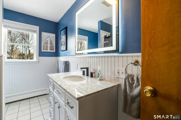 a bathroom with a granite countertop sink and a mirror
