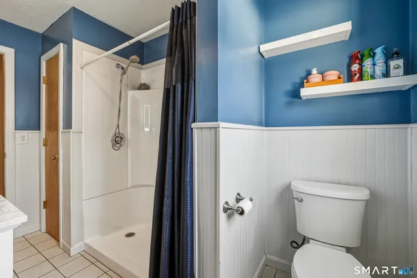 a bathroom with a toilet and a shower