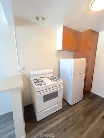 a view of a kitchen with wooden floor and staircase