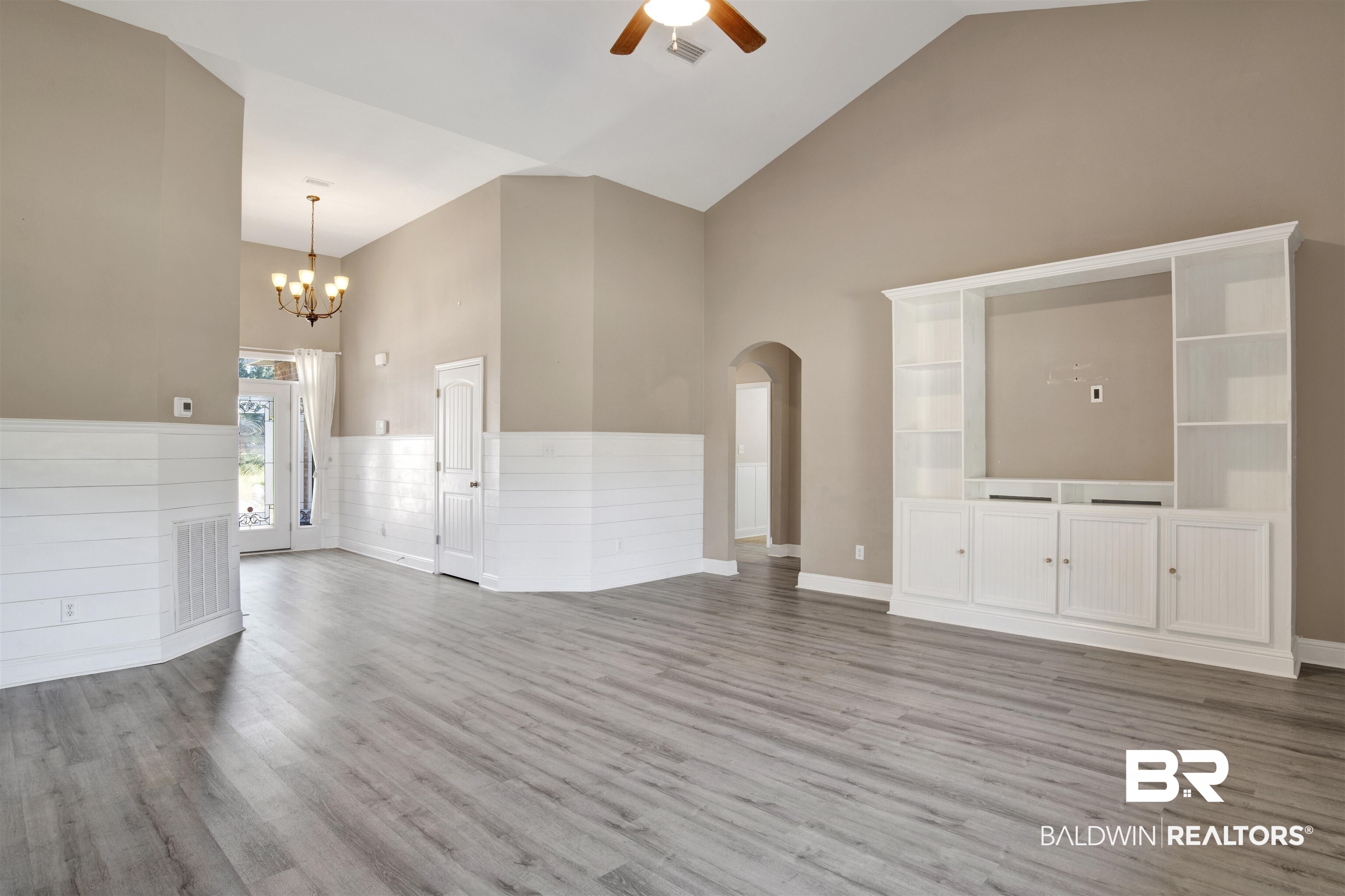 24159 Tullamore Drive Daphne, AL 36526 - Photo 6 of 31 Unfurnished living room featuring ceiling fan with notable chandelier, hardwood / wood-style flooring, and high vaulted ceiling