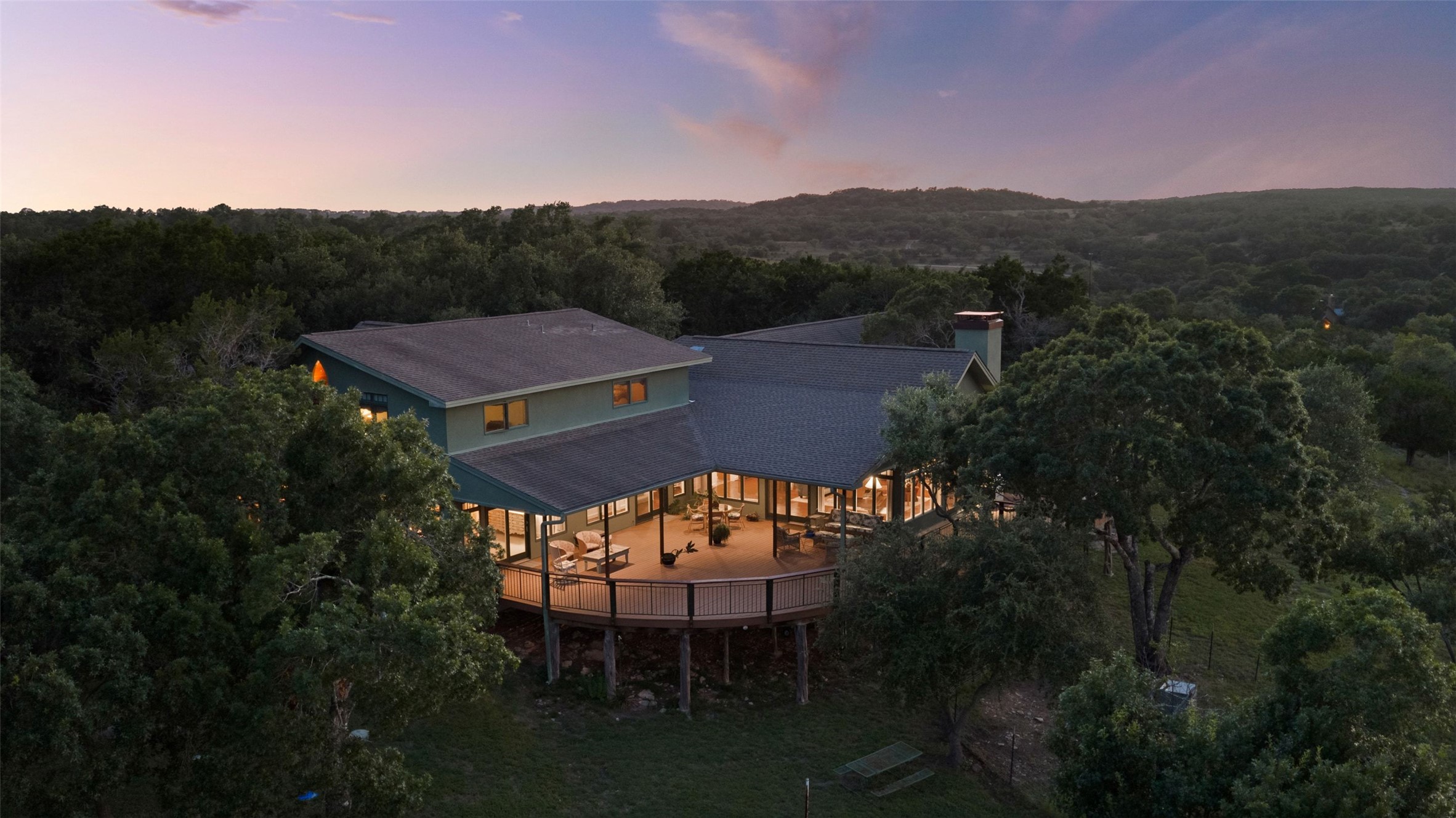 505 Red Corral Ranch Road Wimberley, TX 78676 - Photo 35 of 40 An inviting elevated deck extends from this verdant hillside home, providing breathtaking, secluded views.