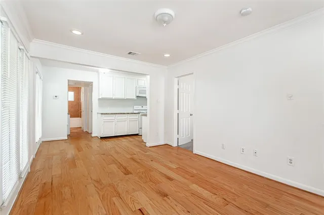 a view of empty room with kitchen and window