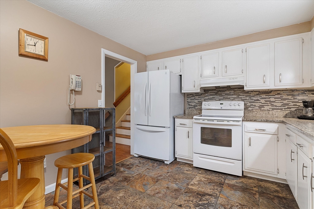 405 Cross Street Boylston, MA 01505 - Photo 10 of 34 a kitchen with a stove a refrigerator and white cabinets