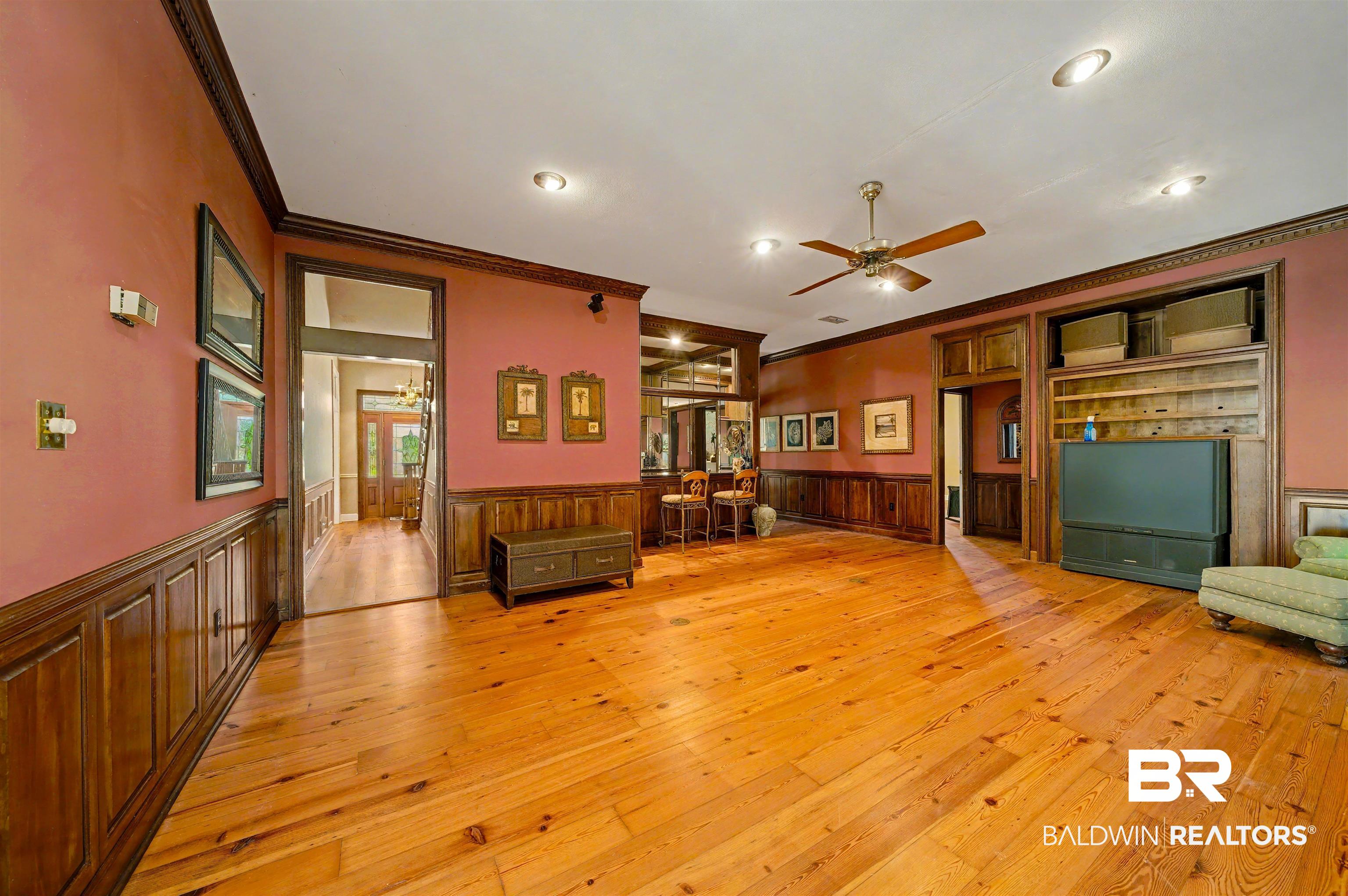 15810 County Road 73 Foley, AL 36535 - Photo 16 of 56 Unfurnished living room with crown molding, light wood-style floors, a ceiling fan, a wainscoted wall, and recessed lighting