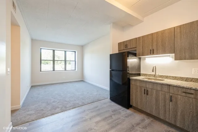 a kitchen with granite countertop a refrigerator and a sink