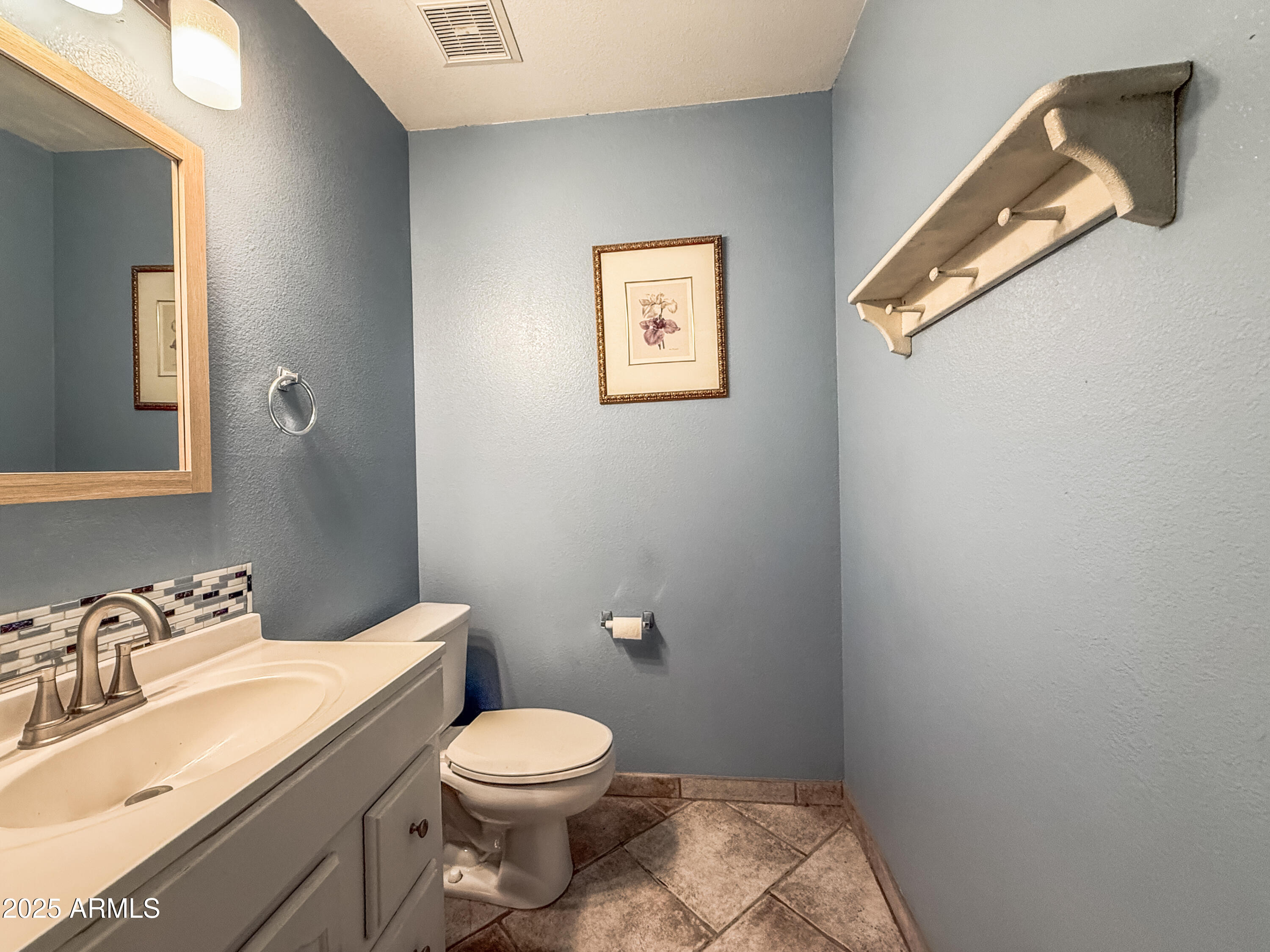 5057 East Delta Avenue Mesa, AZ 85206 - Photo 21 of 26 a bathroom with a toilet a sink and mirror