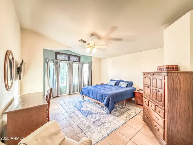 a spacious bedroom with a bed a couch and dresser