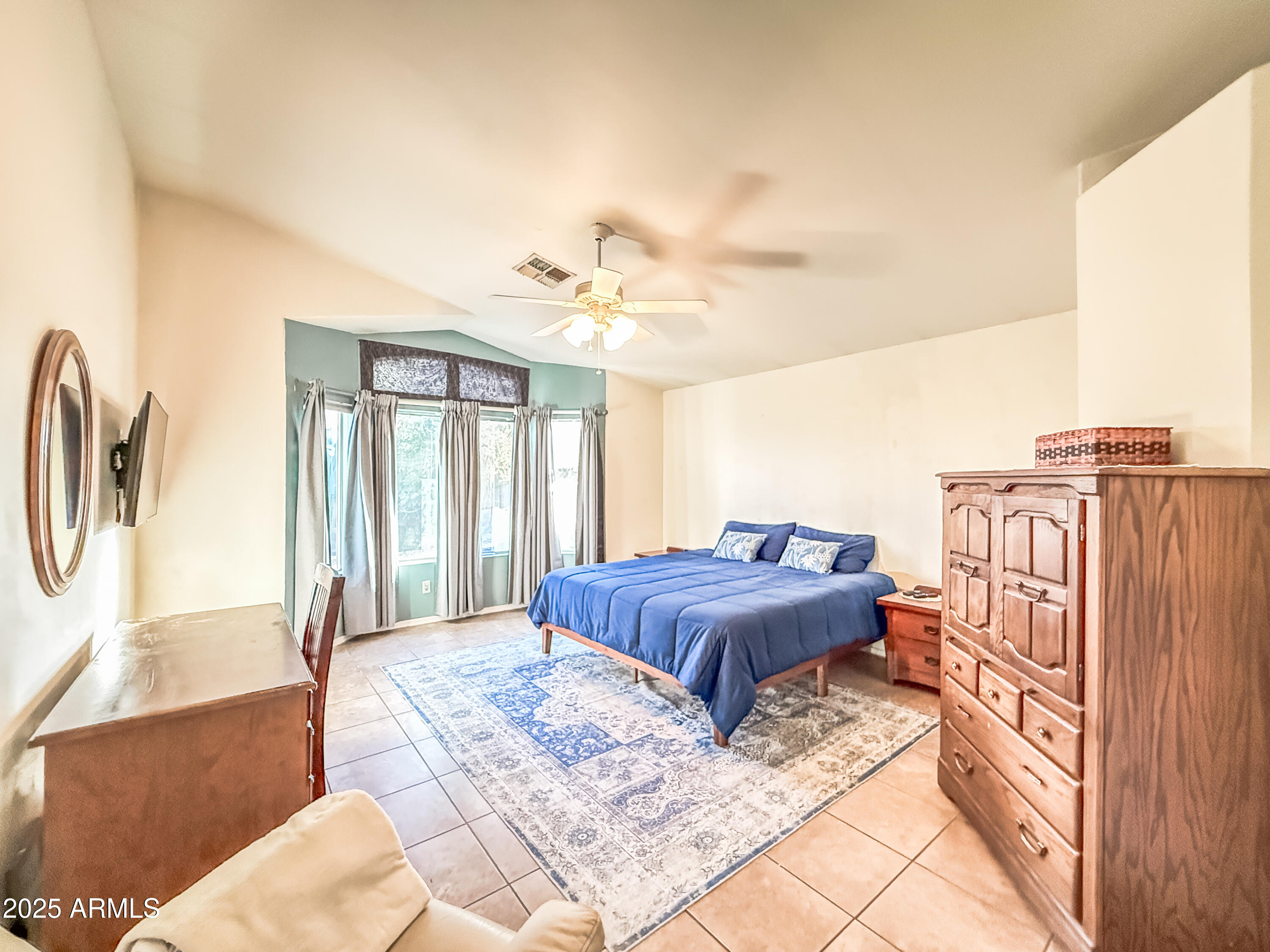 5057 East Delta Avenue Mesa, AZ 85206 - Photo 24 of 26 a spacious bedroom with a bed a couch and dresser