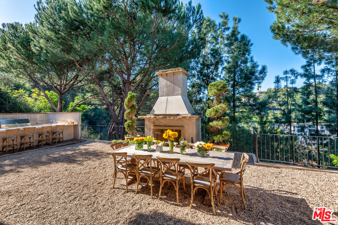 980 Stradella Road Los Angeles, CA 90077 - Photo 28 of 40 a view of a patio with a table and chairs next to a yard