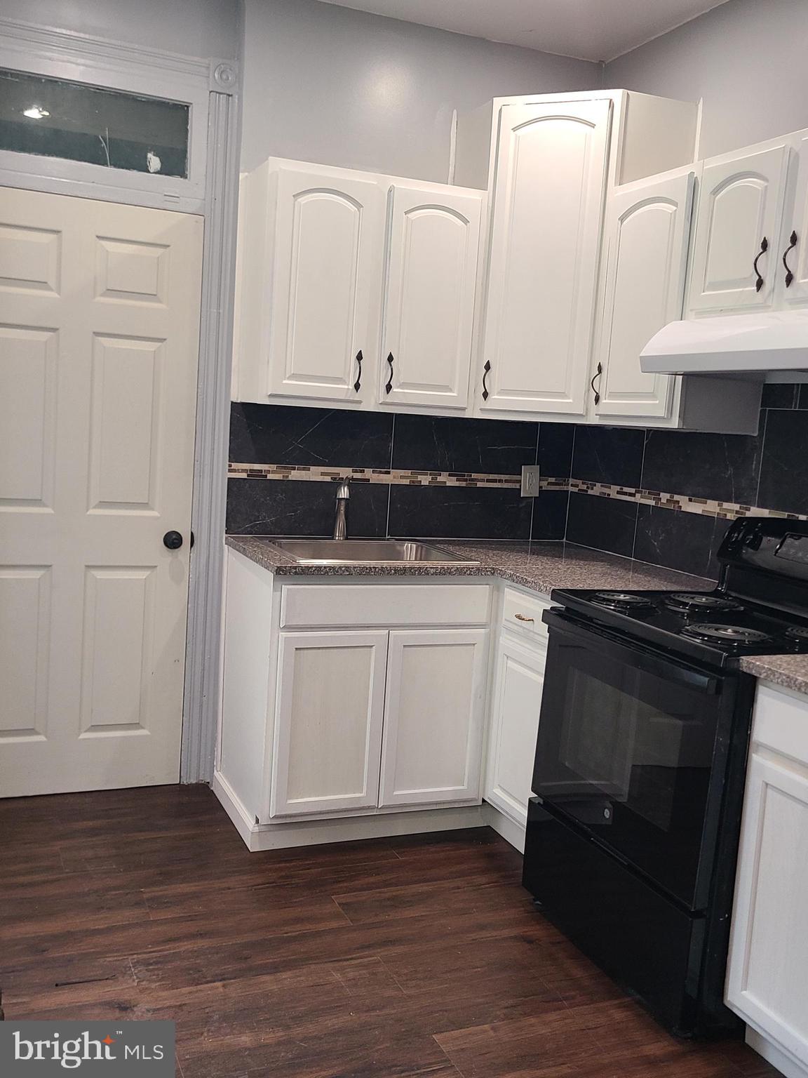 1218 Fidelity Street Reading, PA 19604 - Photo 6 of 14 a kitchen with granite countertop white cabinets and black appliances