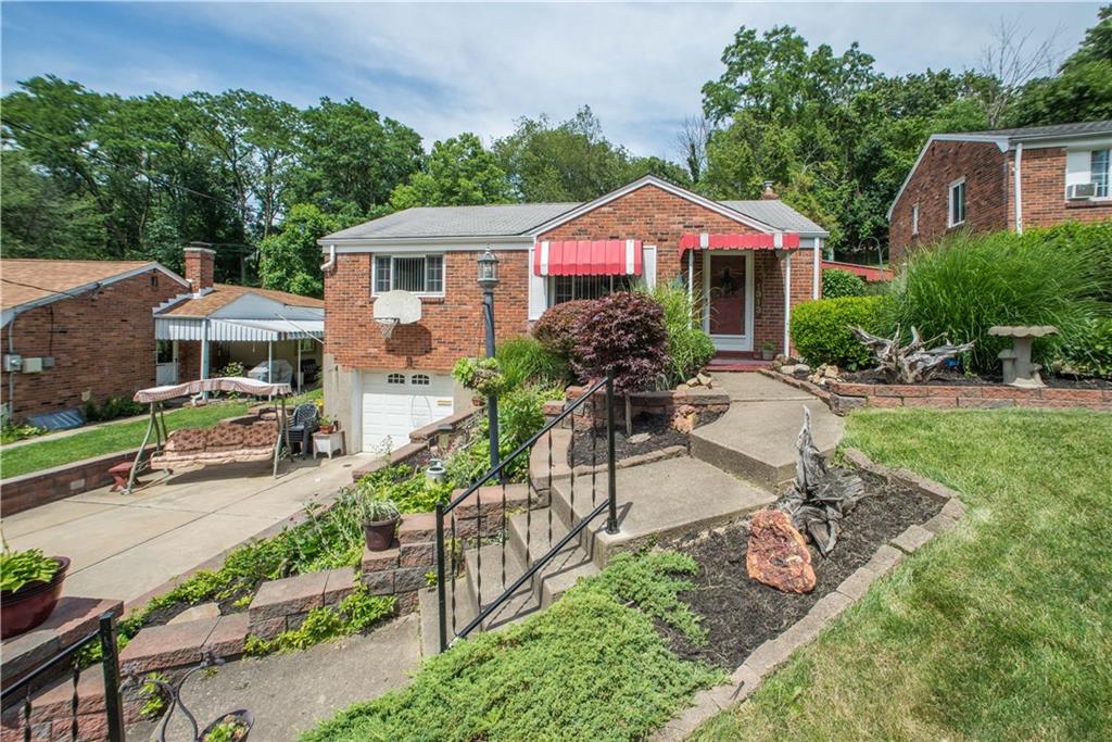 1313 McCully Road Pittsburgh, PA 15234 - Photo 2 of 25 A curved walkway, flanked by low-maintenance landscaping beds and bordered with brick pavers, leads to the covered front entry and enhances the home's curb appeal.