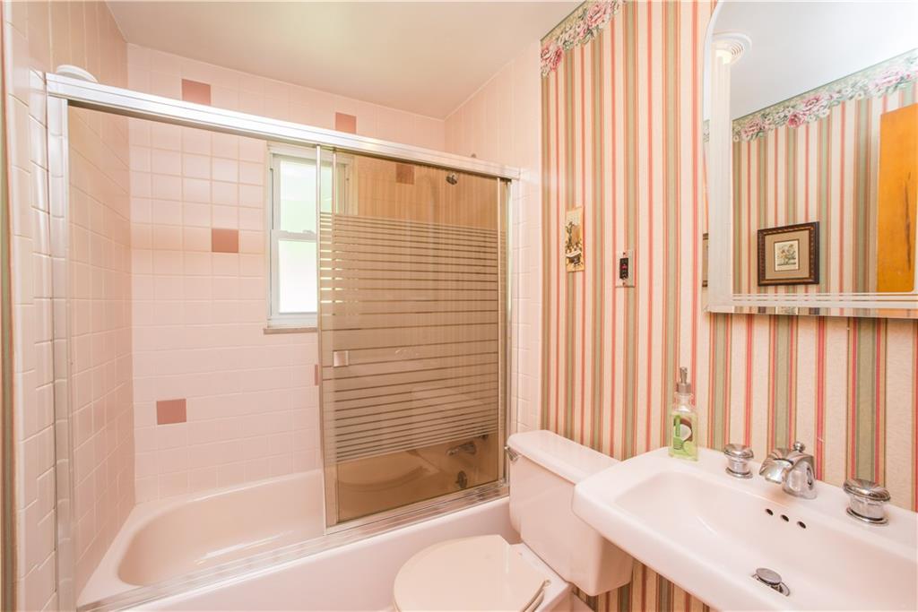 1313 McCully Road Pittsburgh, PA 15234 - Photo 12 of 25 The main bath is fully tiled and offers a combination tub and shower with tile surround. A linen closet is just off the bath in the hallway.