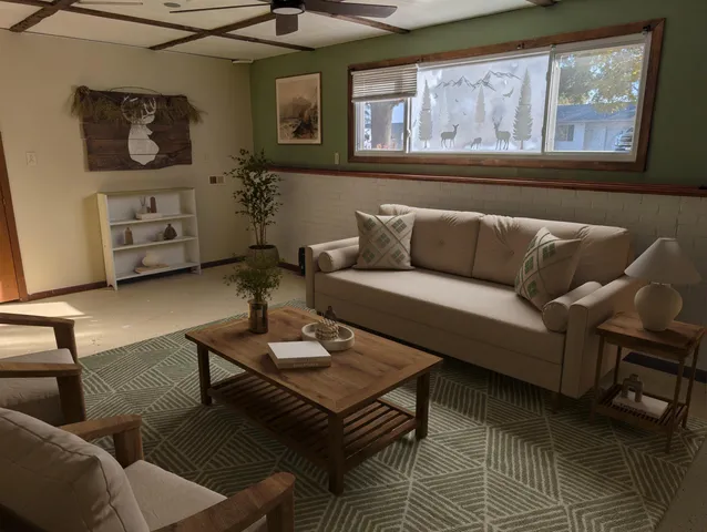 a living room with furniture a rug and wall paintings