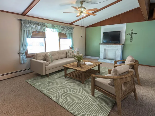 a living room with furniture a large window and a flat screen tv