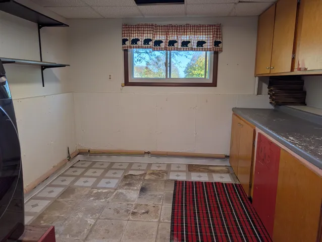 a view of a kitchen with wooden floor and cabinets