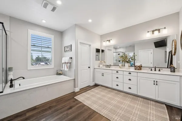 a bathroom with a double vanity sink toilet and shower