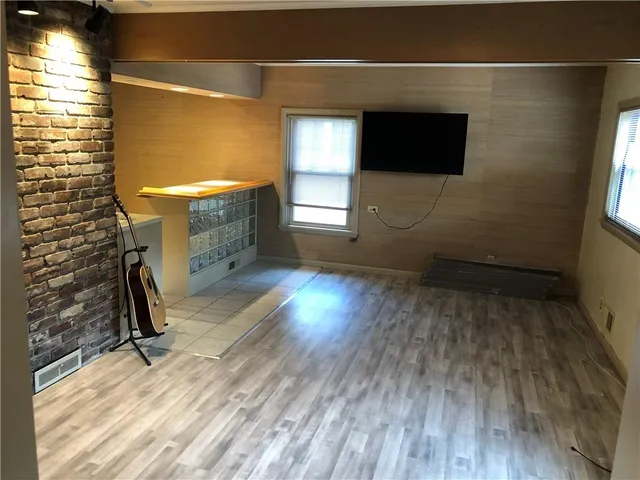a view of a livingroom with wooden floor and a window