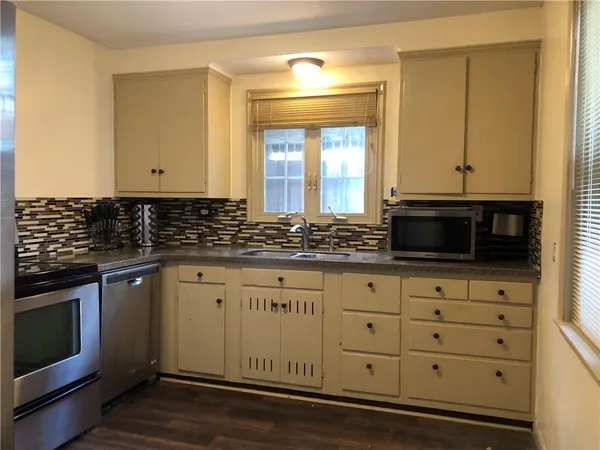 a kitchen with granite countertop white cabinets and stainless steel appliances
