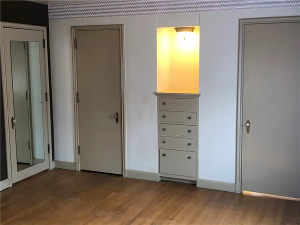 an empty room with windows and closet