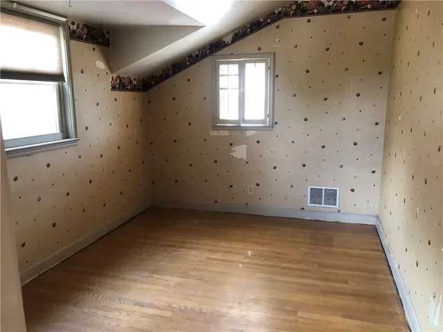 a view of a room with wooden floor and windows