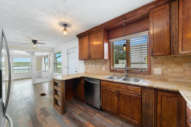 a kitchen with a sink cabinets and wooden floor