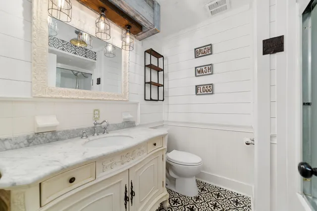 a bathroom with a granite countertop sink toilet and shower