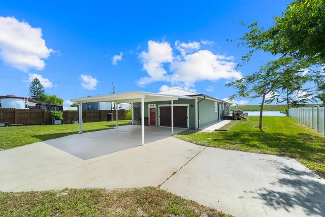 a view of a house with backyard and a tree