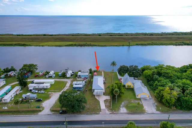 an aerial view of a house with a garden and lake view