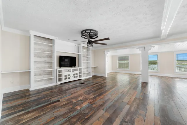 a view of a livingroom with wooden floor and a ceiling fan