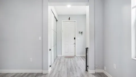 a view of a hallway with wooden floor and closet area