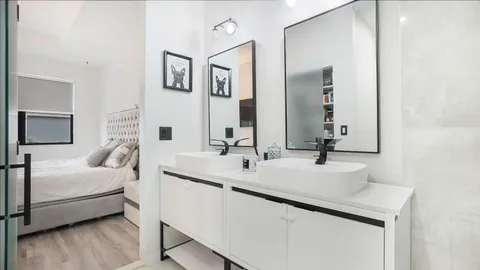 a en suite bathroom with a double vanity sink and mirror