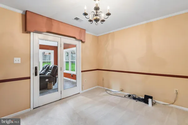 a view of a hallway with a chandelier and livingroom view