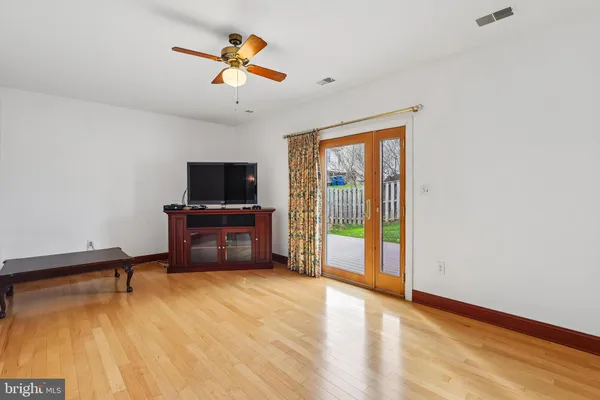 a living room with a flat screen tv on dresser and a table