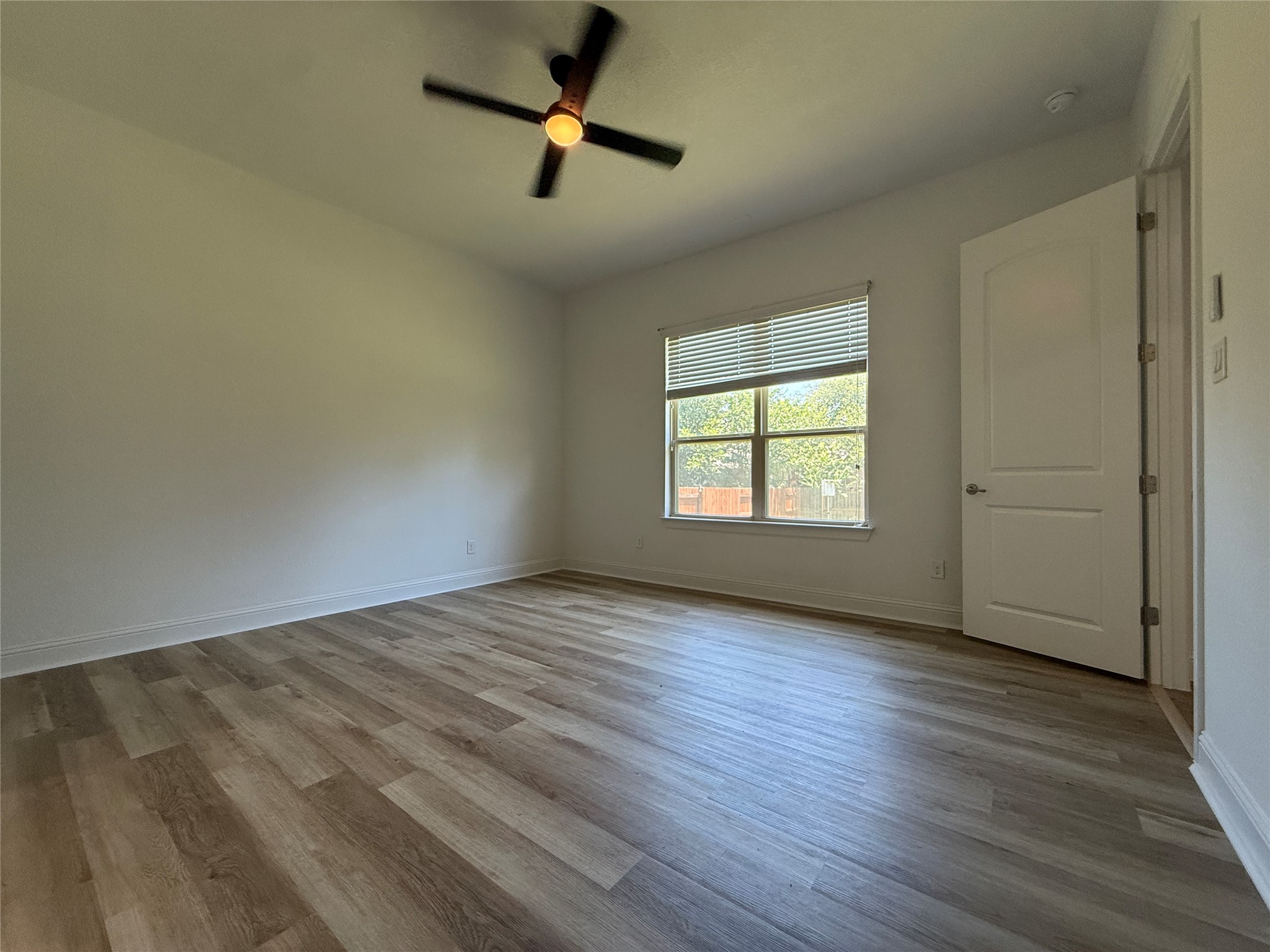 1512 Long Shadow Lane Georgetown, TX 78628 - Photo 11 of 19 an empty room with wooden floor ceiling fan and windows