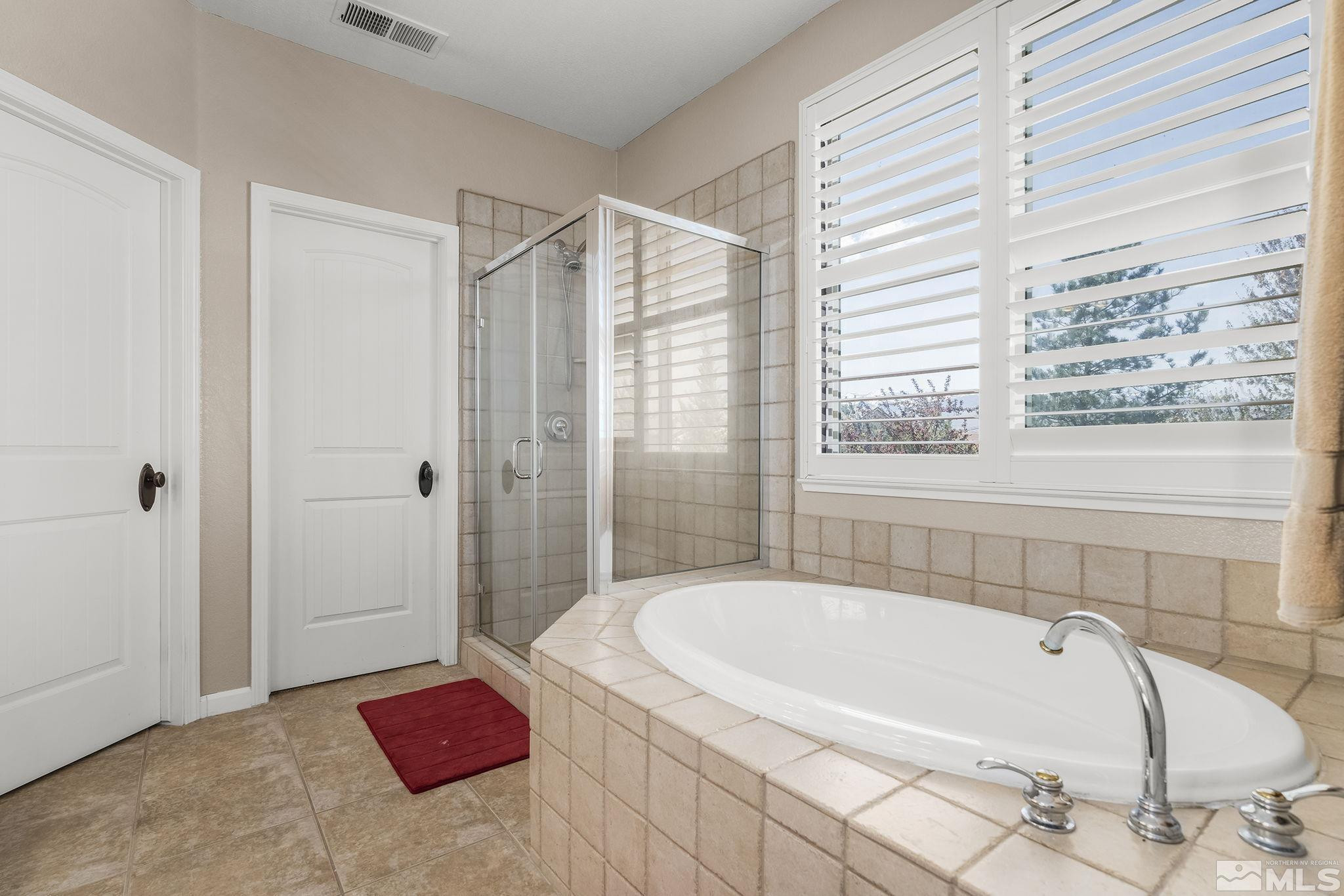 10537 Fort Morgan Way Reno, NV 89521 - Photo 18 of 30 a bathroom with a tub a sink and a window