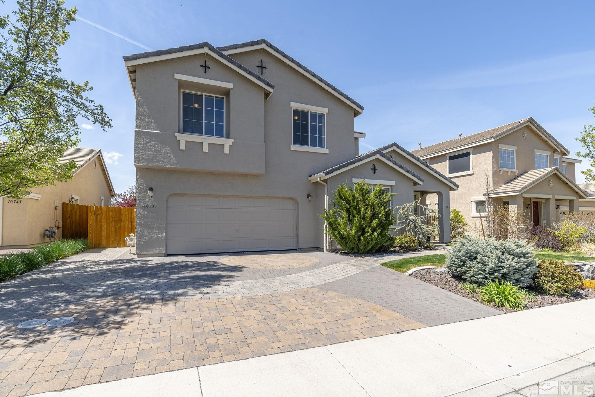10537 Fort Morgan Way Reno, NV 89521 - Photo 3 of 30 a front view of a house with a yard and a garage