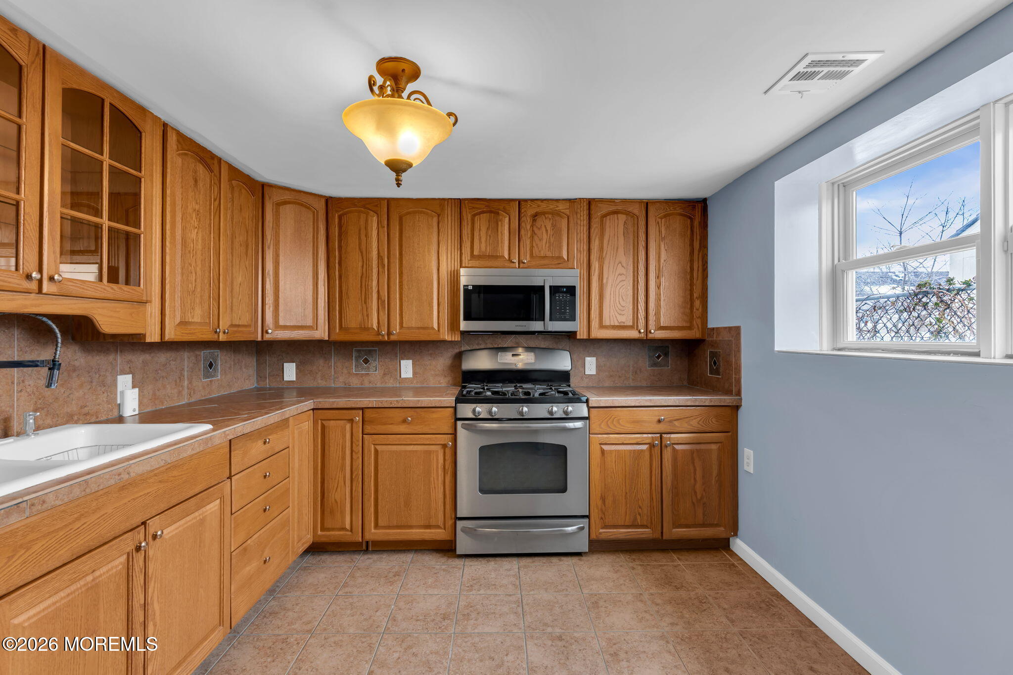 1208 Pine Tree Way, Unit BACK HOUSE Belmar, NJ 07719 - Photo 9 of 24 a kitchen with stainless steel appliances granite countertop a stove a sink and a microwave