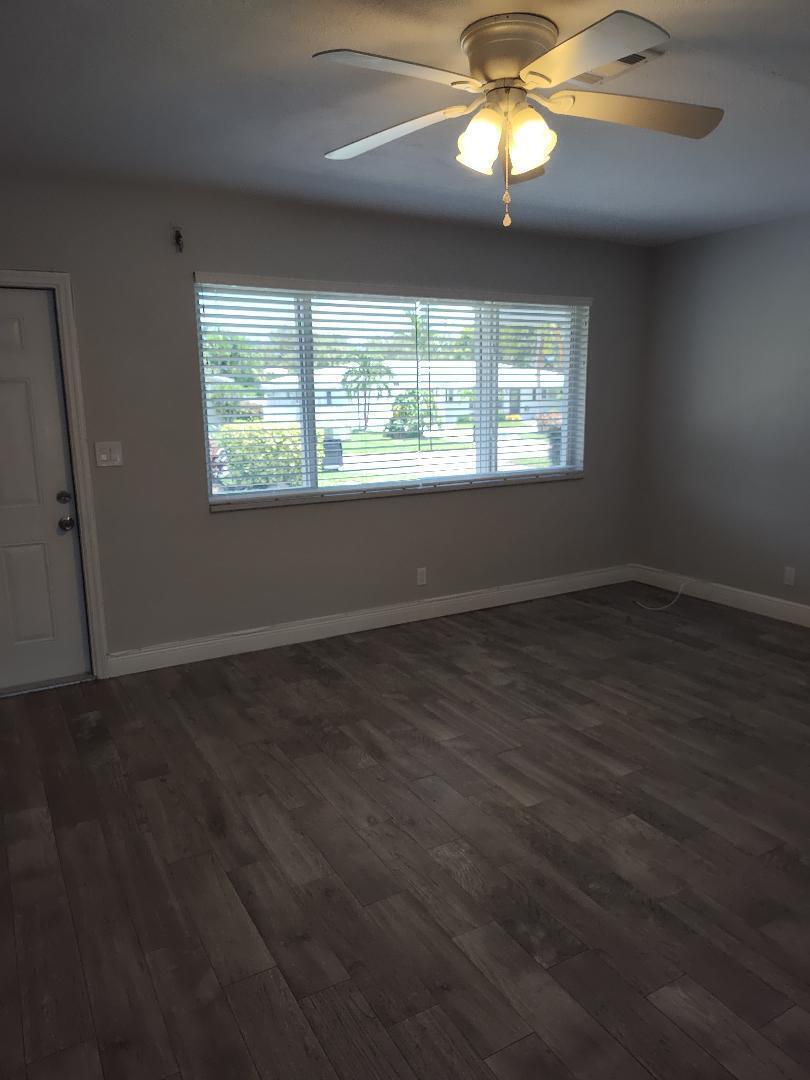 2248 Northeast 37th Street Lighthouse Point, FL 33064 - Photo 7 of 19 an empty room with wooden floor chandelier fan and windows