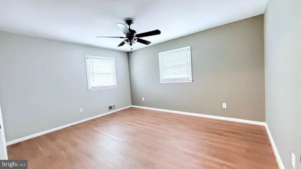 a view of a big room with wooden floor and windows in a room