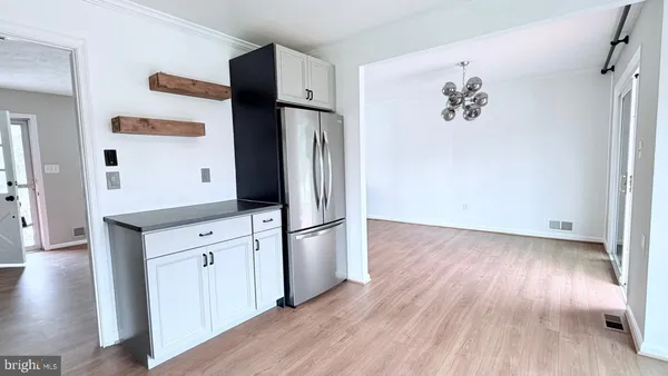 an empty room with wooden floor and cabinet