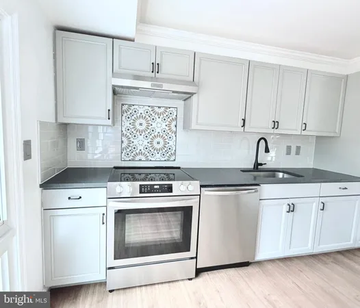 a kitchen with cabinets appliances and a sink