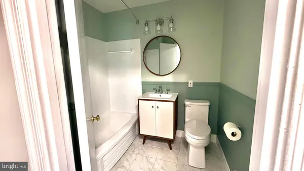 a bathroom with a toilet a sink and a mirror
