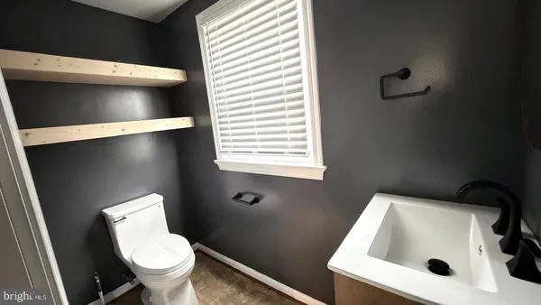 a white toilet sitting next to a sink and vanity