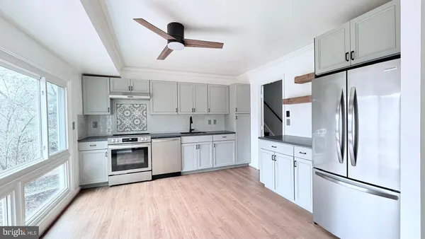 a kitchen with white cabinets and stainless steel appliances