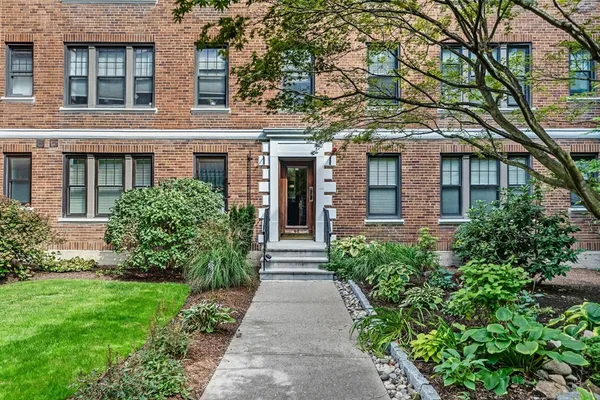 front view of a brick house with a yard