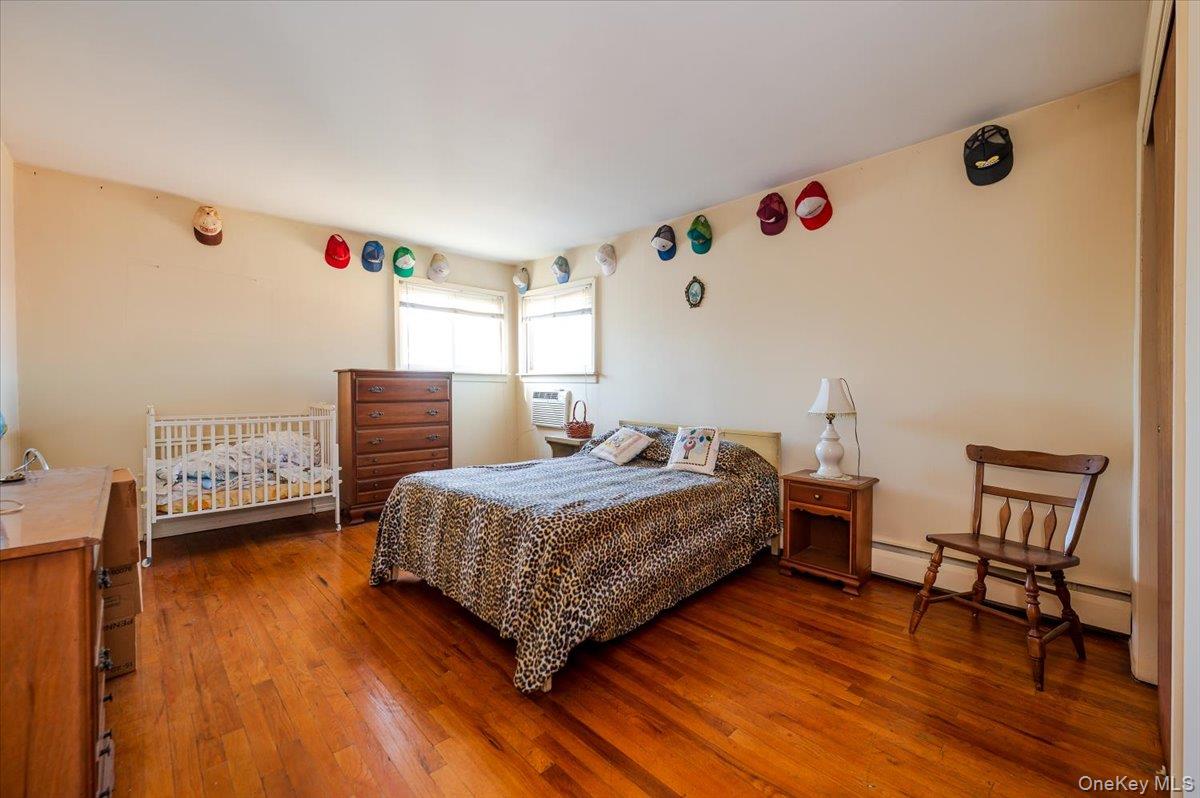 10 Meadow Road Inwood, NY 11096 - Photo 12 of 22 Bedroom with baseboard heating and wood-type flooring