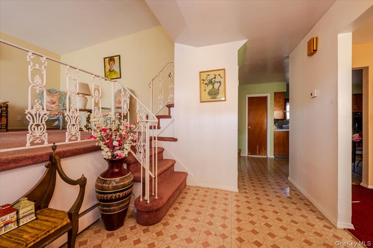 10 Meadow Road Inwood, NY 11096 - Photo 2 of 22 Stairway with tile patterned floors and a baseboard heating unit