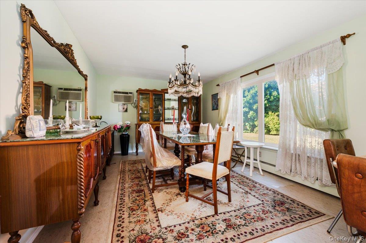 10 Meadow Road Inwood, NY 11096 - Photo 7 of 22 Dining space featuring a chandelier, baseboard heating, and a wall unit AC