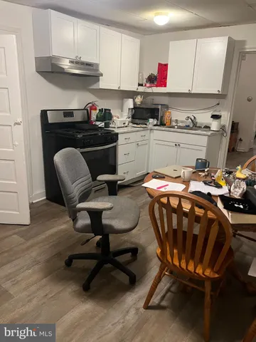 a kitchen with stainless steel appliances a stove a sink dishwasher and cabinets with wooden floor