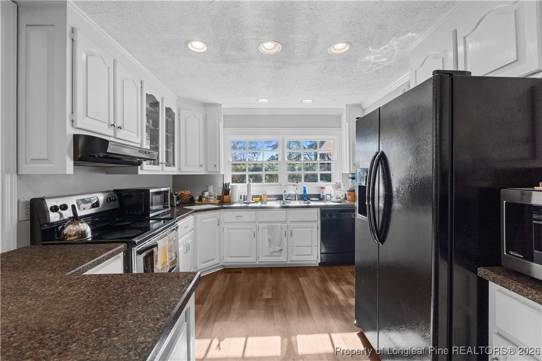 1717 Raeford Road Fayetteville, NC 28305 - Photo 5 of 25 a kitchen with granite countertop a refrigerator a sink a stove and cabinets